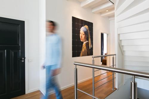 a man walking down a staircase with a painting on the wall at Bacán in The Hague
