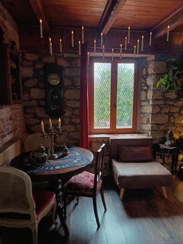 une chambre avec une table, un banc et une fenêtre dans l'établissement La Pensine du célèbre sorcier, à Bourogne