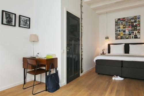 a bedroom with a bed and a desk and a desk at Bacán bed&business in The Hague