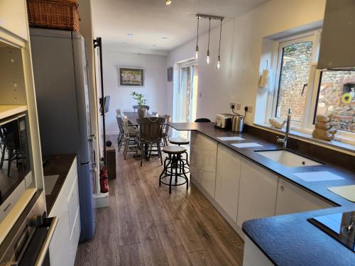 a kitchen with white cabinets and a counter top at AnchorageWells Entire Cottage for 8 with 4 King Ensuite Rooms in Wells next the Sea