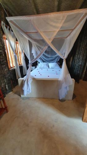 a bed in a tent in a room at Kirepwe Ecco Camp Watamu in Watamu