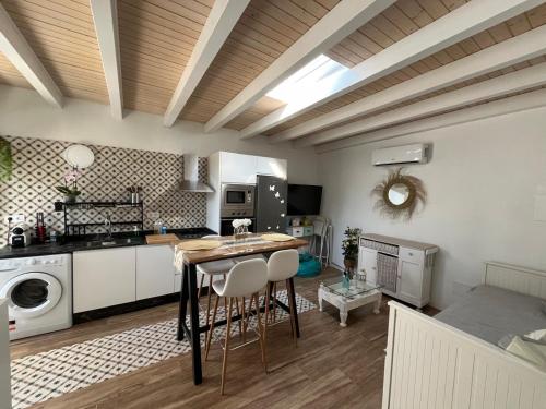 Una cocina y una sala de estar con mesa y sillas. en Villa de la luz, en Tarifa