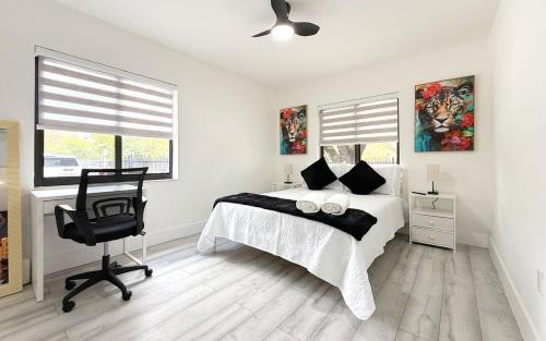 a bedroom with a bed and a chair and windows at Modern Oasis near Brickell & Marlins 2 Bedroom Free parking in Miami