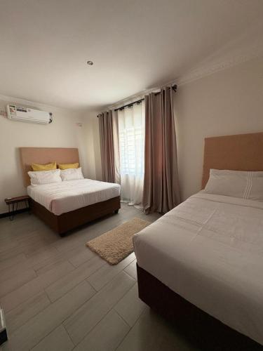 a hotel room with two beds and a window at Pumuzika in Livingstone
