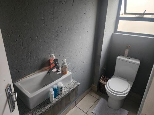 a small bathroom with a toilet and a sink at House of Bellavina in Fourways
