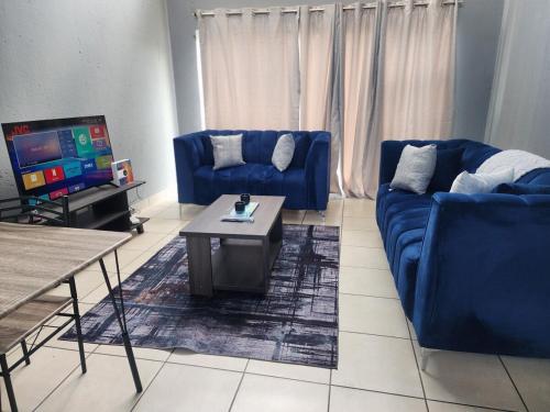 a living room with two blue couches and a table at House of Bellavina in Fourways