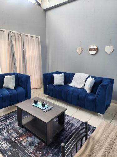 a living room with a blue couch and a coffee table at House of Bellavina in Fourways