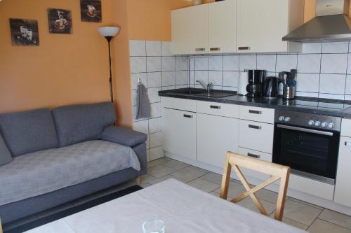 a living room with a couch and a kitchen at Ferienunterkünfte Familie Berger in Dessau