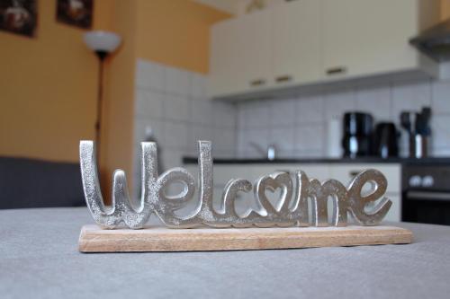 a metal sign that says welcome sitting on a table at Ferienunterkünfte Familie Berger in Dessau