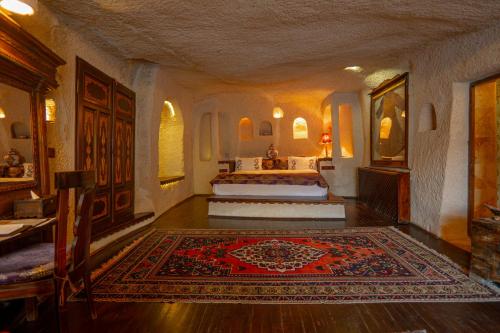 a bedroom with two beds and a rug on the floor at Cappadocia Gamirasu Cave Hotel in Urgup