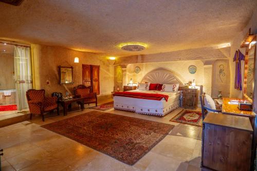 a bedroom with a bed and a table and chairs at Cappadocia Gamirasu Cave Hotel in Urgup