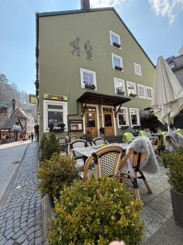 a building with chairs and a table and an umbrella at Hotel Alt Montjoie in Monschau