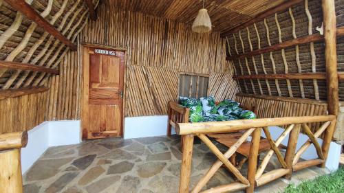 a room of a thatched hut with a bed in it at Kirepwe Ecco Camp Watamu in Watamu