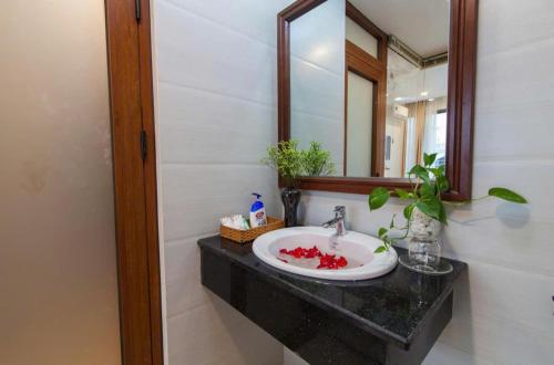 ein Badezimmer mit Waschbecken und Spiegel in der Unterkunft Coral Hotel Phu Quoc in Phu Quoc