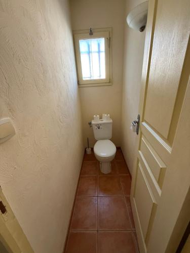 a small bathroom with a toilet and a window at Maison dans village vacances avec piscine in Gaujac