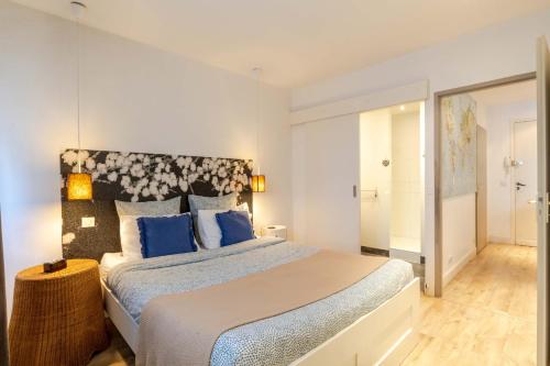 une chambre avec un grand lit avec des oreillers bleus dans l'établissement La perle-Proche Vieille-ville & Gare, à Annecy