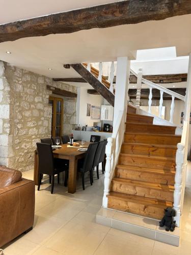 une salle à manger avec une table et un escalier dans l'établissement Moissac14, à Eymet
