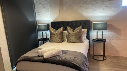 a bedroom with a large bed with two lamps at Swift Studios No4 in Cape Town