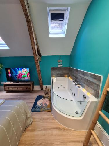 La grande salle de bains est pourvue d'une baignoire et d'une télévision. dans l'établissement L'île Turquoise- Balnéo Privée I Relaxation, à Boulogne-sur-Mer