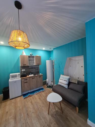 - un salon avec des murs bleus, un canapé et une table dans l'établissement L'île Turquoise- Balnéo Privée I Relaxation, à Boulogne-sur-Mer