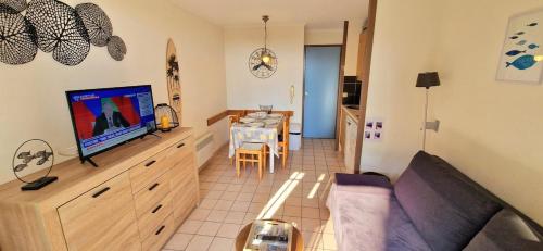 un salon avec un canapé, une télévision et une table dans l'établissement 