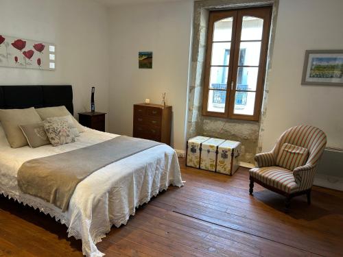 une chambre avec un lit, une chaise et une fenêtre dans l'établissement Moissac14, à Eymet