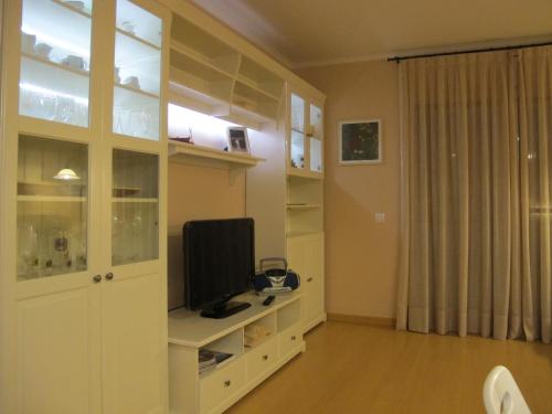 Nice apartment in Costa Brava في بالافروجيل: غرفة معيشة مع تلفزيون على خزانة بيضاء