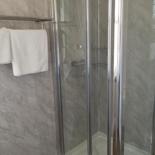 a shower stall with a glass door in a bathroom at Woodthorpe Hotel in Skegness