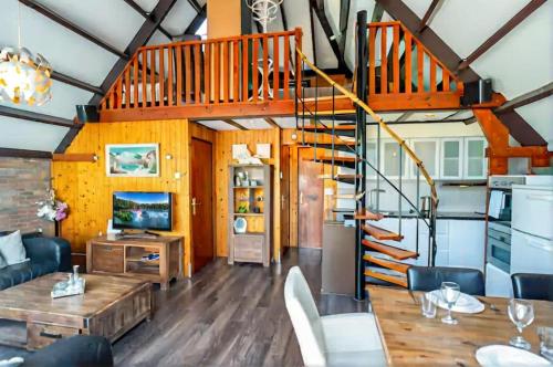a living room with a spiral staircase and a table at Spacious Nature Escape, house for 6 near Amsterdam & Sea in Opmeer