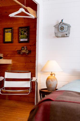 a bedroom with a bed and a chair and a lamp at Huisje aan de Vijver in Hamme