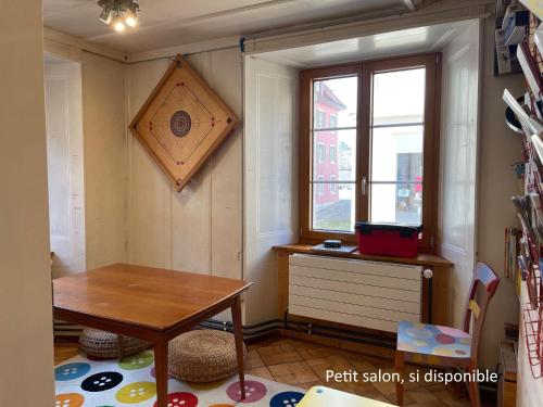 a small room with a table and a window at Maison La Coquille in La Chaux-de-Fonds