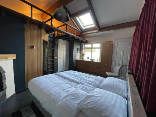 a large bed in a bedroom with a window at Wellness bungalow met privésauna en hot tub - Glamping aan de Maas in Kessel