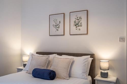 a bedroom with a bed with two pictures on the wall at Crown Street Apartments in Wellington