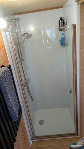 La salle de bains est pourvue d'une cabine de douche et d'un rideau de douche. dans l'établissement Gîte en matériaux naturels Sauna, couchers de soleil et chevaux, à Vausseroux