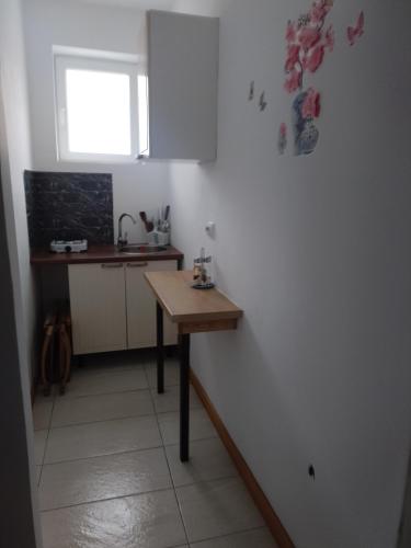 a small kitchen with a table and a sink at Garsoniera in Ocniţa