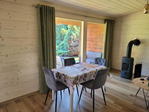 a dining room with a table and chairs and a stove at Apartement u Jędrusia w ogrodzie in Żywiec