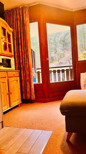 - un salon avec deux fenêtres et un canapé dans l'établissement Appartement Morzine Avoriaz, à Morzine