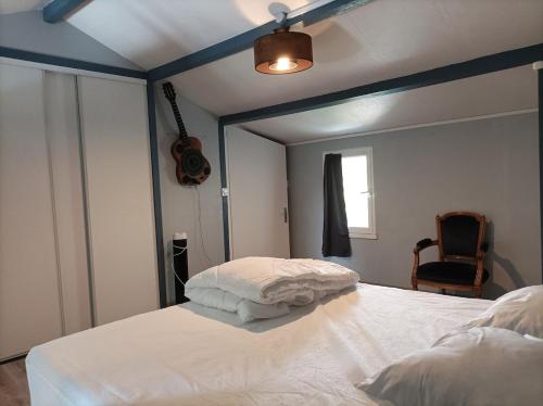 - une chambre avec un lit blanc et un plafond bleu dans l'établissement Gîte Rock - La Note Bleue, à Sainte-Radégonde-des-Noyers