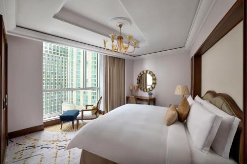 a bedroom with a large white bed and a large window at Raffles Makkah Palace in Makkah
