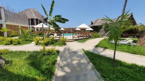 a path leading to a resort with a swimming pool at Kirepwe Ecco Camp Watamu in Watamu