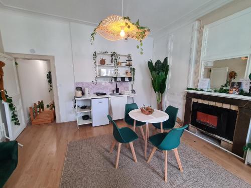 un salon avec une table et des chaises dans l'établissement Jungle Évasion - Détente & Comfort, à Boulogne-sur-Mer