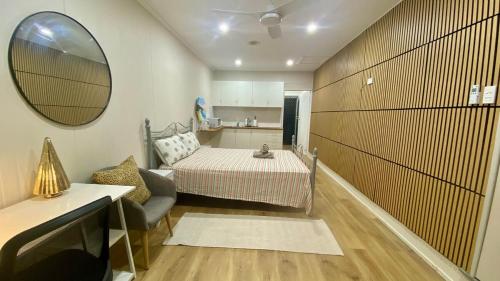 a small room with a bed and a mirror at Modern Studio Room Retreat in Harristown