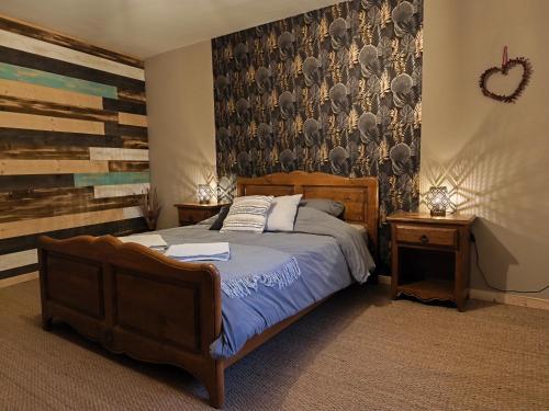 a bedroom with a bed and a wall with a mural at Gîte des trois petits oiseaux in Picarreau