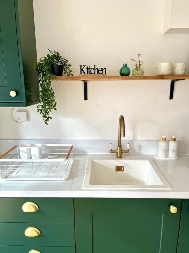 a kitchen with a sink and a kitchen sign on a shelf at Waterside House - Luxury Home near Alton Towers & Trentham - Free Parking & Garden in Stoke on Trent