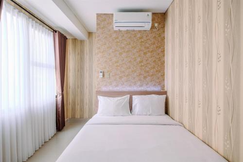 デポックにあるElegant and Comfy 2BR at Transpark Cibubur Apartment By Travelioの大きな白いベッドと窓のある寝室