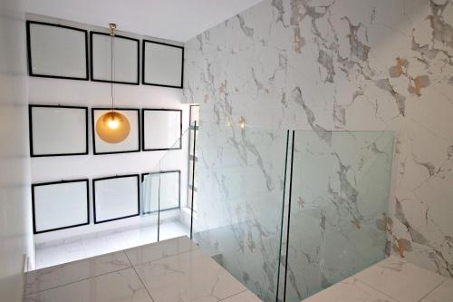 a bathroom with a glass shower and a lamp at Luxury Stay in Hurlingham Mansion in Sandton