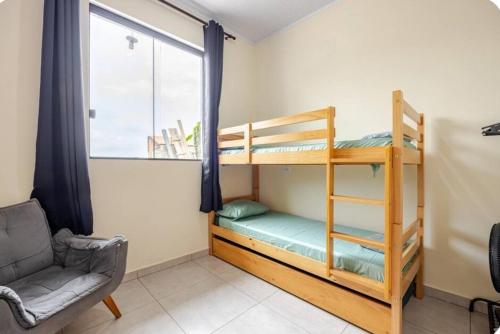een slaapkamer met een stapelbed, een stoel en een raam bij Pousada da Vila Araçariguama-SP in Araçariguama