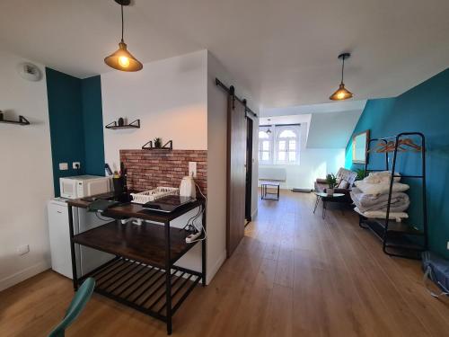 une chambre avec un bureau et un salon aux murs bleus dans l'établissement Le Sommet de l'Opale I Spacieux & Confort, à Boulogne-sur-Mer