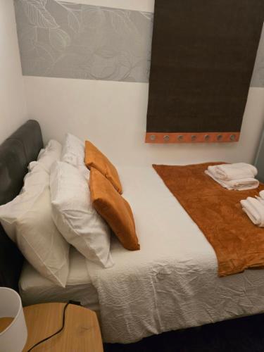 a bed with white pillows and a brown blanket at Room away from home in Shinfield