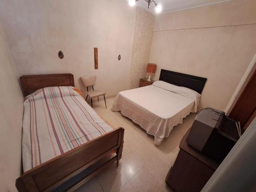 a small bedroom with two beds and a chair at Güemes y la costa in Mar del Plata